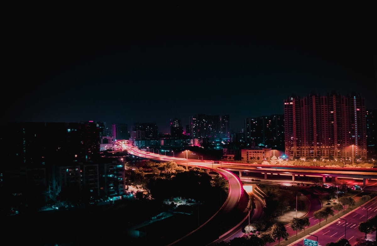 A light-stained highway and city at night.